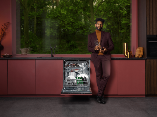 Man standing next to dishwasher.